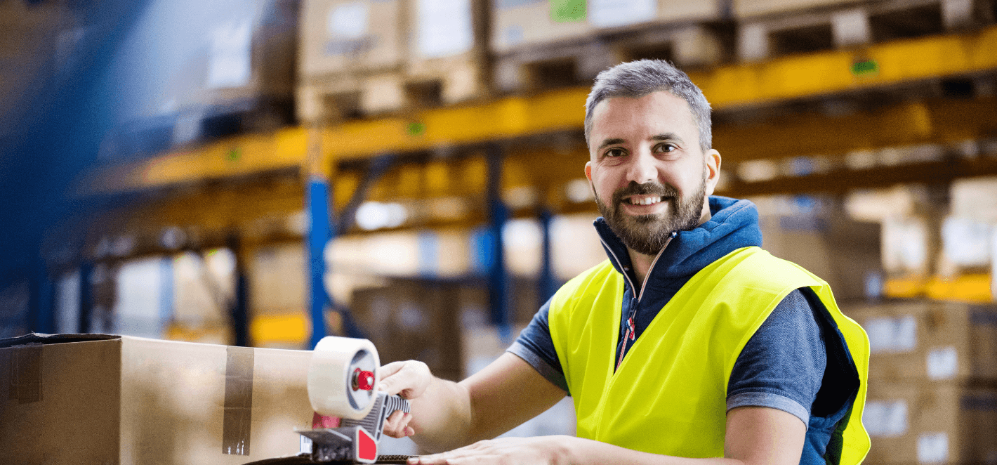 préparateur de commande qui ferme des cartons